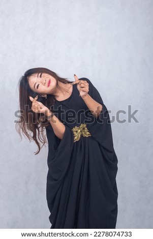 Asian chinese muslim headscarf hijab woman greeting ramadan fasting eid al fitr and eid al adha on white background. the smiling expression of his hand showing your love symbol 