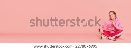 Jolly emotions. Banner of jolly young girl wearing sport clothes and smiling over pink background. Concept of sport, human emotions, student life, spring, summer, mental health, leisure time