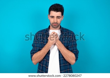 Sad Young caucasian man wearing casual shirt over blue background desperate and depressed with tears on her eyes suffering pain and depression  in sadness facial expression and emotion concept Royalty-Free Stock Photo #2278080247
