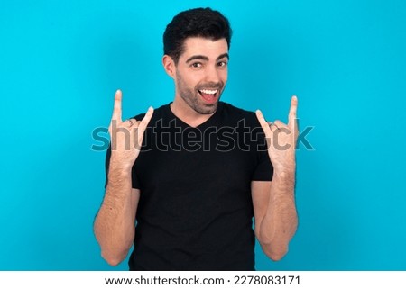 MODEL makes rock n roll sign looks self confident and cheerful enjoys cool music at party. Body language concept.