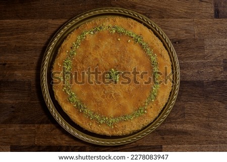 Arabic traditional mix kunafa. desserts rough and soft konafa in trays sweet with pistachio and pine on top.Top view with close up. Royalty-Free Stock Photo #2278083947