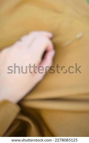 female left hand with blurry cream screen
