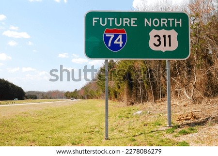 A sign along a stretch of highway advises drivers the road will soon be designated as an interstate highway by the department of transportation