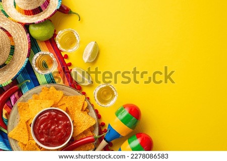 Cinco-de-mayo concept. Top view photo of nacho chips salsa sauce hot pepper tequila with salt and lime sombrero colorful striped serape and maracas on isolated vivid yellow background with copyspace Royalty-Free Stock Photo #2278086583