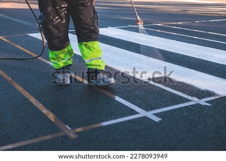 Process of making new road surface markings with a line striping machine, workers improve city infrastructure, demarcation marking of pedestrian crossing with hot melted paint on asphalt pavement
 Royalty-Free Stock Photo #2278093949