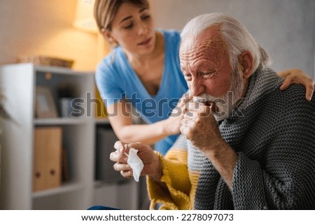 Doctor consoling senior patient at home. Old people senior man with winter seasonal illness fever cold problems. Concept of mature retired with disease. Front view of senior man coughing 