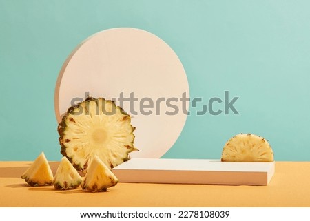 Front view of fresh pineapple slices and white empty podium on pastel blue background. Minimal art background with blank platform for display cosmetics and product of pineapple extract.