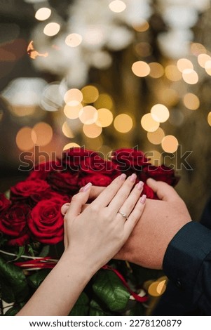 Marriage proposal. Will you marry me. She said yes. A couple hand with wedding ring on a bouquet of red roses. Love concept. Elegant floral template for design for Valentine's Day. Closeup. Top view. Royalty-Free Stock Photo #2278120879