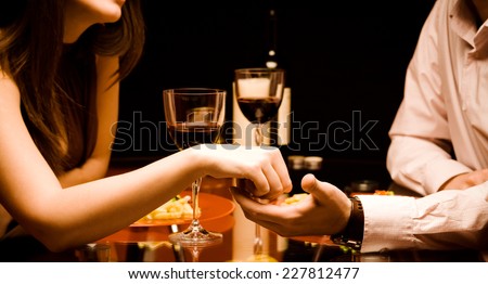 Man and woman at the restaurant - holding hands together Royalty-Free Stock Photo #227812477