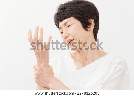 Asian middle aged woman having the joint pain in white background