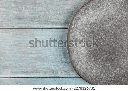 Beautiful empty plate with blue concrete background flat lay top view