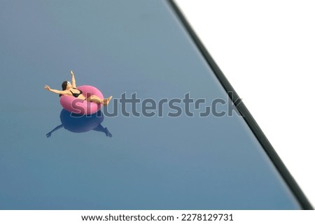 Miniature people toy figure photography. Virtual travel concept, girl swimming with rubber tube ring above smartphone, isolated on white background. Image photo