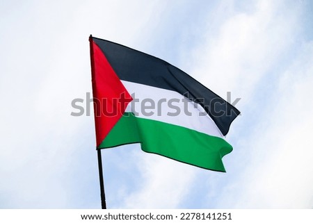 Palestine national flag waving in the wind. International relations concept. Royalty-Free Stock Photo #2278141251