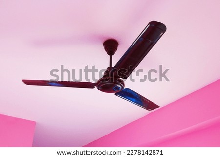 Large ceiling fan in a room with pink walls. Royalty-Free Stock Photo #2278142871