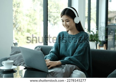 Happy young Asian saleswoman looking at camera welcoming client. Smiling woman executive manager, secretary offering professional business services holding digital tablet standing in office. Portrait