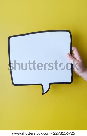 Speech bubble in hand on a yellow background. Comic cloud with a place for text