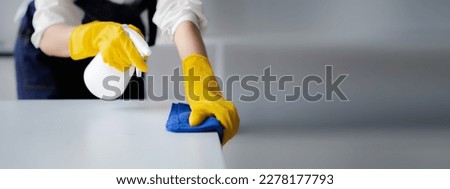 Person cleaning the room, cleaning staff is using cloth and spraying disinfectant to wipe the desk in the company office room. Cleaning staff. Maintaining cleanliness in the organization. Royalty-Free Stock Photo #2278177793