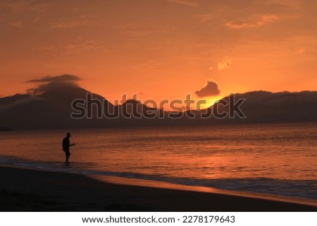Beautiful sunset view with orange clouds over the beach