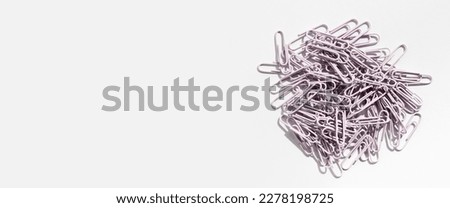 Stationery, paper clips on a white background. Top view, flat lay. Banner.