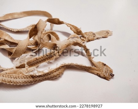 Worn and damaged beige women's bra straps
