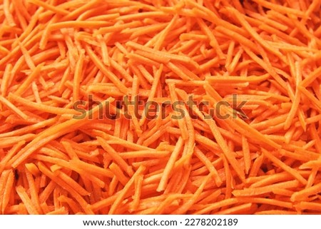 Grated Carrots Background is Spinning. Fresh Juicy Chopped Carrots. Food Orange Color Backdrop. Shredded Carrot Abundance is Rotating. Crushed, Cut Vegetables for Soup, Garnish, Salad. Healthy Eating