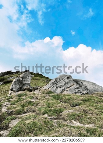 Big rock on a steep hill with a beautiful blue sky