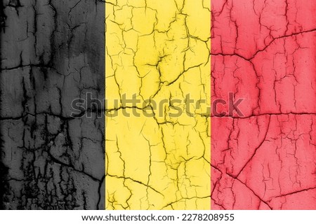 Flag of Belgium on cracked wall, textured background.