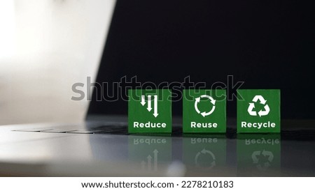 The green wooden blocks placed on the Laptop with symbols and texts “ reduce, reuse and recycle” . It is the concept of reducing the electronic waste, saving the world and environmental conservation. Royalty-Free Stock Photo #2278210183