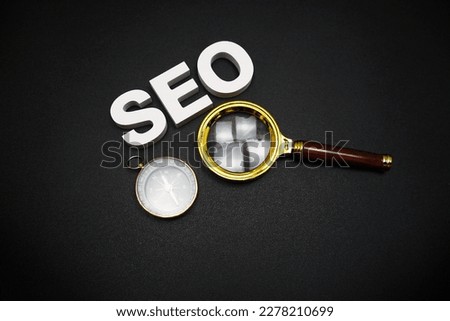 SEO (search engine optimization) text message with magnifying glass on black background