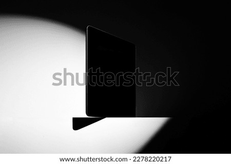 Tablet computer mockup template standing on a table side, deep shadows, real photo. Isolated surface to place your design. 