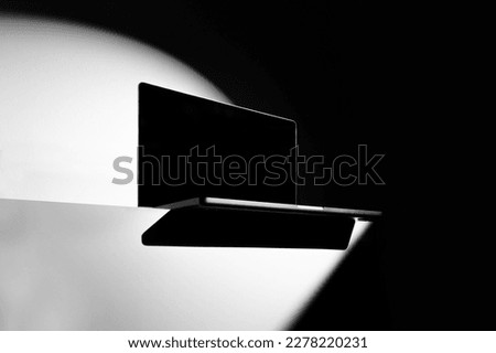 Laptop mockup template standing on a table side, deep shadows, real photo. Isolated surface to place your design.  Royalty-Free Stock Photo #2278220231