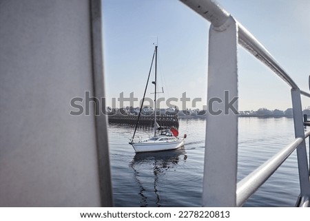 Port Louis, Bretagne, France : beautiful little sailing boat with sailors, on calm water near Lorient, sunny say