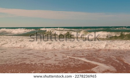 Sea, waves on beach in summertime against blue sky, slow motion. Travel concept, Landscapes overlooking beach sea sand and blue sky. Ocean, breeze drives wave to beach. Wind raises white waves on sea
