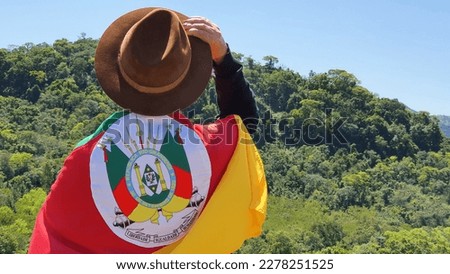Gaucho with hat and flag of the state of Rio Grande do Sul - Southern Brazil. Nature background. Royalty-Free Stock Photo #2278251525