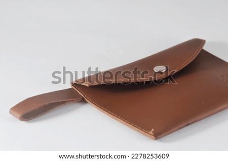 A brown leather purse isolated on a white background.