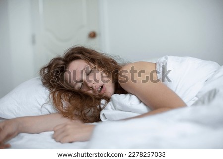 young girl sleeps in the morning in bed and snores loudly with her mouth open, the concept of person have problem with sleep and breathing Royalty-Free Stock Photo #2278257033