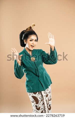 asian woman in green kebaya standing with hands opened on isolated background