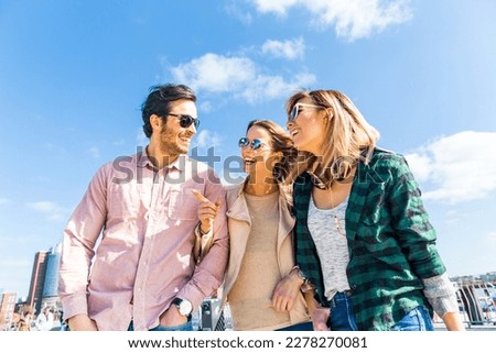 Multiracial group of friends having fun in Hamburg - Authentic scene with two women and one man, laughing and embracing, enjoying a day together - Friendship and lifestyle concepts Royalty-Free Stock Photo #2278270081