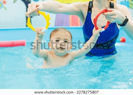 Little boy 2 years old are in the pool. Swimming lessons for young children.