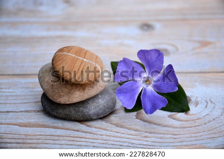 Three zen stones on old wood with flowers