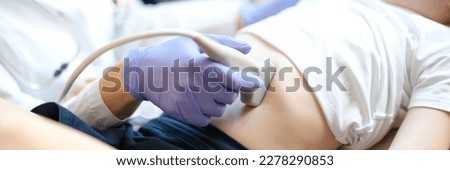 Sonographer moves transducer on little girl belly. Doctor examines belly of small patient in hospital. Royalty-Free Stock Photo #2278290853