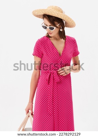 Girl model in a pink dress on studio background.