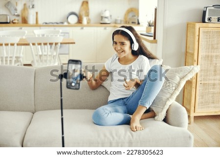 Happy preteen girl blogger record video for vlog, makes videocall, lead stream with virtual friends use modern tech. Streamer activity, igeneration, fun and home use internet, cellphone screen view Royalty-Free Stock Photo #2278305623