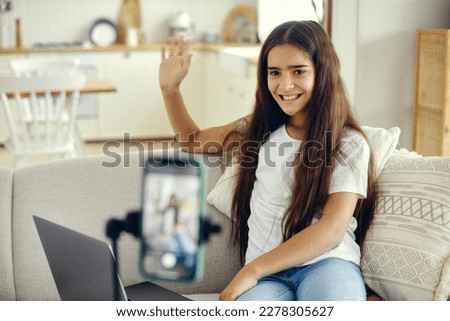 Girl blogger sit on sofa greeting virtual friends, record video for vlog, make call, lead stream with friends use modern tech. Streamer activity, igeneration, fun and home use internet. Communication Royalty-Free Stock Photo #2278305627