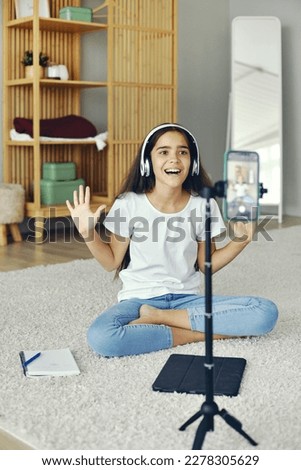 Pretty preteen 12s girl in headphones blogger record video for vlog, make call, lead stream with friends use modern tech. Streamer activity, igeneration Z, fun at home use internet Royalty-Free Stock Photo #2278305629