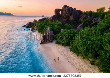 Anse Source d'Argent, La Digue Seychelles, a young couple of Caucasian men and Asian women on a tropical beach during a luxury vacation in Anse Source d'Argent, La Digue Seychelles Royalty-Free Stock Photo #2278308359