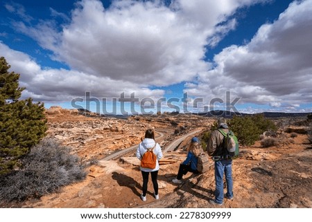 Family relaxing on hiking trail. Friends standing on top of the mountain. Potash Road or the Lower Colorado Scenic Byway, Moab, Utah,USA Royalty-Free Stock Photo #2278309999