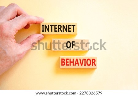 Internet of behavior symbol. Concept words Internet of behavior on wooden block on a beautiful white table white background. Businessman hand. Business Internet of behavior concept. Copy space.