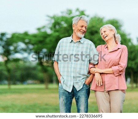 Happy active senior couple walking and holding hands outdoors Royalty-Free Stock Photo #2278336695