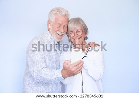 Video call concept. Happy senior couple using smartphone together for video chat online communication, smiling senior people expressing love and emotion